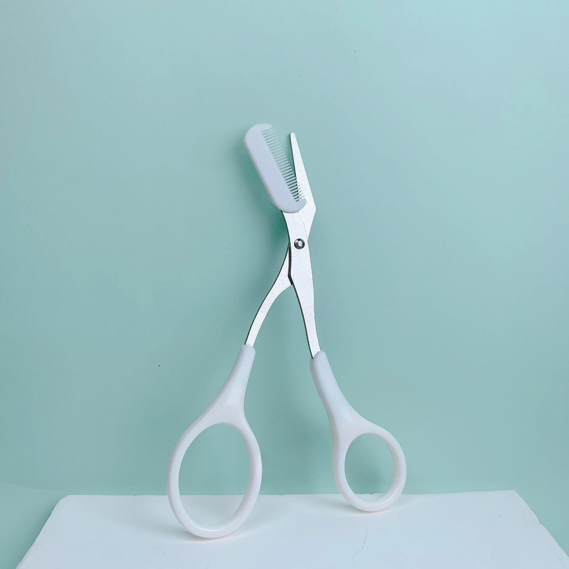 Pink eyebrow trimming scissors with built-in comb - stainless steel, precise grooming tool, creating perfect eyebrows